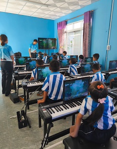 Alice and children learning to play keyboards